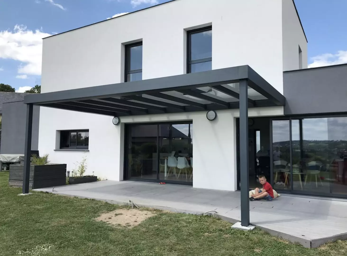 Pergola alu anthracite toit vitré, baies coulissantes grises, terrasse carrelée grise