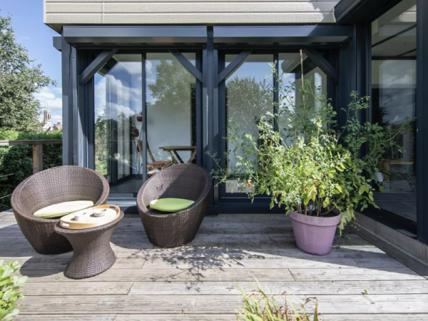 Terrasse bois, baies coulissantes alu anthracite et volets roulants, bardage clair