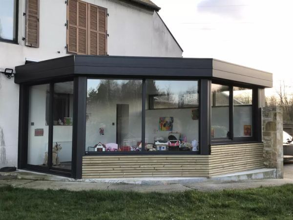 Extension toit plat alu anthracite et bardage bois clair, grandes parois vitrées