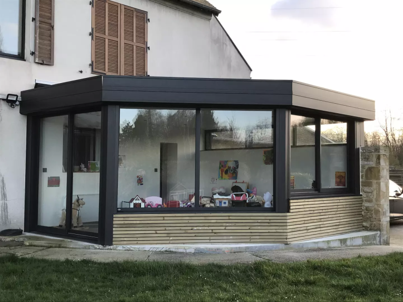 Extension toit plat alu anthracite et bardage bois clair, grandes parois vitrées