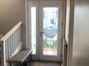 Hall entree porte blanche vitrage geometrique, escalier et banquette capitonnee