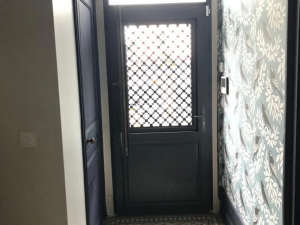 Porte entrée anthracite grille trèfles blanche, papier peint oiseaux dans le hall