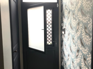 Porte anthracite ouvrant vitré intérieur, grille trèfles et papier peint bleu
