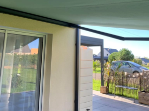 Store banne gris clair, lambrequin deploye sur terrasse et salon exterieur