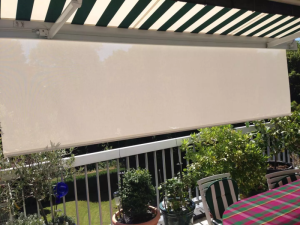 Store banne rayures vert et blanc avec lambrequin creme sur balcon fleuri