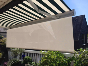 Store banne rayure vert et blanc, lambrequin beige deploye sur terrasse