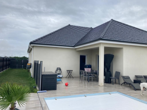 Piscine volet blanc, terrasse carrelée et pergola avant pose, mobilier gris
