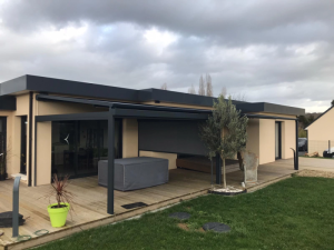 Pergola double anthracite, store zip et terrasse bois devant maison moderne
