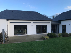 Façade blanche, coffres stores bannes anthracite au-dessus de grandes baies
