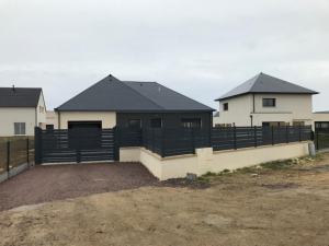 Portail battant et clôture anthracite lames, pavillon beige et gravier devant
