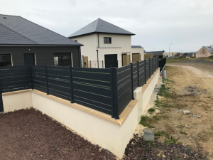 Clôture anthracite lames horizontales sur muret briques, vue angle lotissement