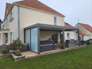 Pergola anthracite sur terrasse, spa recouvert et canape resine, maison creme