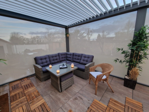 Pergola lames blanches, stores lateraux creme, salon rotin gris sur dalles