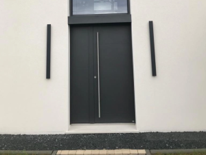 Porte entree anthracite, poignee inox verticale et luminaires noirs de part et d'autre