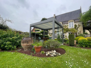 Pergola bioclimatique anthracite, paroi vitree devant maison en pierre