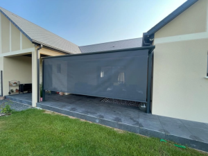 Store vertical anthracite semi-transparent le long terrasse carrelee grise