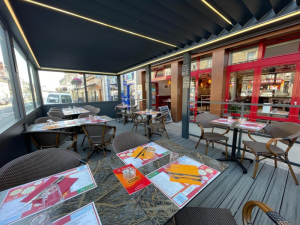 Pergola noire LED lames, terrasse restaurant chaises rotin et vitrages