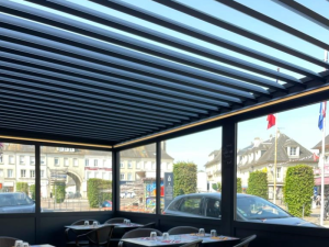 Pergola bioclimatique lames ouvertes, terrasse restaurant vue sur place