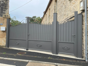 Portail et portillon anthracite volutes rosettes devant mur pierre