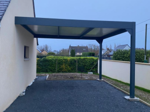 Carport alu anthracite adossé, toit plaques blanches sur gravier et haie