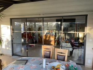 Cloison coulissante vitrée noir atelier, lambris bois clair et salle à manger
