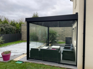 Veranda alu noir vitree, salon rotin gris face piscine bachee sur terrasse carrelee