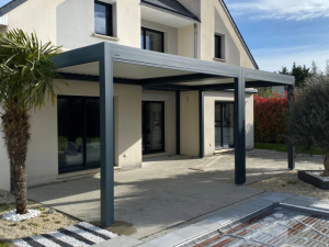 Pergola bioclimatique anthracite, terrasse beton, palmiers et bord piscine
