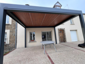 Contre-plongée pergola Brustor anthracite, plafond lames bois sur terrasse en gravier