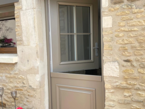 Porte fermiere taupe, battant superieur ouvert a petits bois sur mur pierre