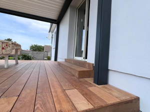 Marches bois vers baie coulissante blanche, sous pergola anthracite a lames claires
