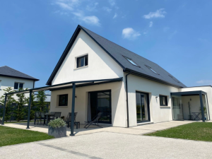 Maison blanche, pergola anthracite et toile rétractable sur terrasse gravier et pelouse