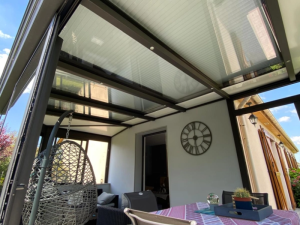 Veranda plafond mixte vitre et isolant, spots et fauteuil oeuf rose