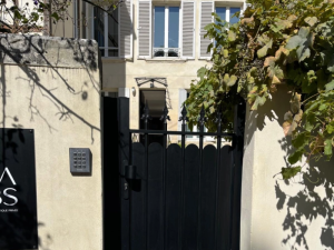 Portillon noir festonné bas, vigne avec grappes au-dessus du mur de pierre