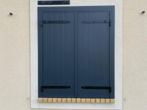 Volets battants anthracite fermes, pentures noires et appui briques jaunes