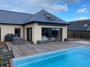 Extension ardoise, baie coulissante noire, terrasse bois et piscine