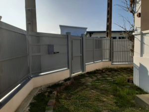 Cloture grise lames verticales, portillon sur muret blanc et boite lettres