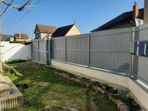 Cloture grise lames verticales et portail coulissant sur muret jardin