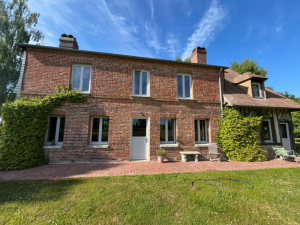Maison brique rouge, fenetres gris clair, porte vitree et jardin ensoleille