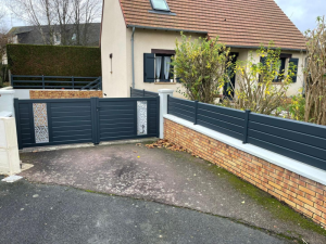 Portail anthracite décor ajouré et clôture lames sur muret briques devant pavillon