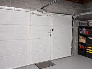 Porte garage sectionnelle blanche intérieur, portillon intégré et rails au plafond