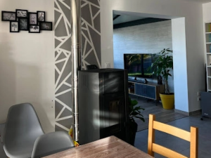 Poêle à granulés noir et conduit inox, mur à motifs géométriques gris dans le séjour