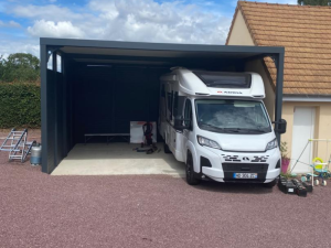 Carport haut anthracite, camping-car blanc Adria sous lames latérales