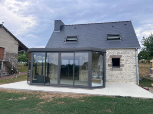 Extension verre gris angle biseauté, longère pierre et lucarnes entrouvertes