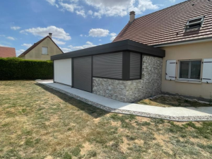 Extension toit plat, volets roulants gris et parement pierre sur jardin