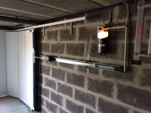 Garage parpaing, porte garage latérale blanche, rail horizontal et moteur allume