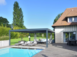 Pergola bioclimatique anthracite face piscine, maison colombages et pelouse