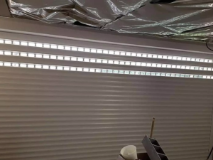 Volet roulant garage gris clair, lames a hublots sous plafond isolant