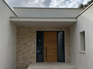 Porte entrée lames bois horizontales, imposte vitrée et parement pierre clair