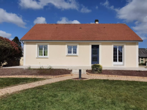 Pavillon creme, fenetres blanches petits bois, porte bleue et terrasse claire