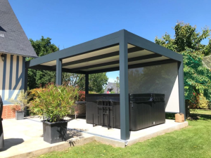 Pergola anthracite toit lames claires, store latéral beige et spa noir sur dalles